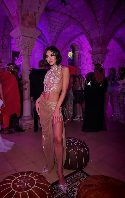 Nude gown draped with pearls and a high slit